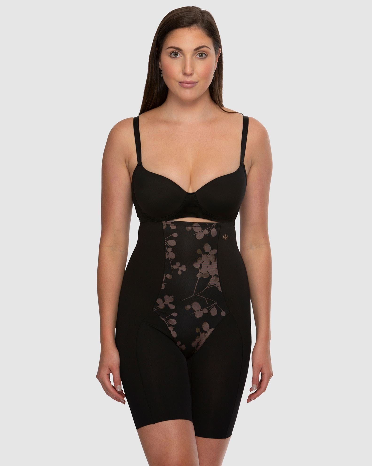 Woman wearing a black shapewear garment on a white background