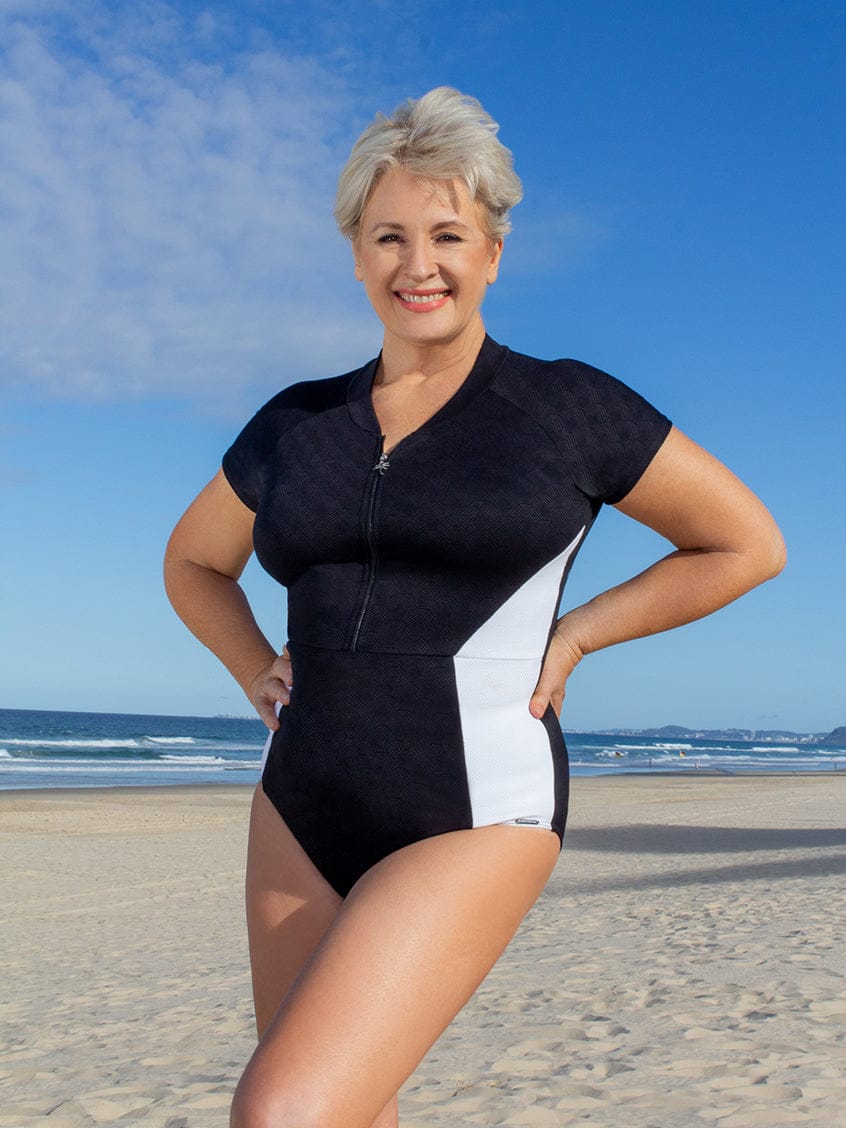 Woman wearing a black and white swimsuit on a beach
