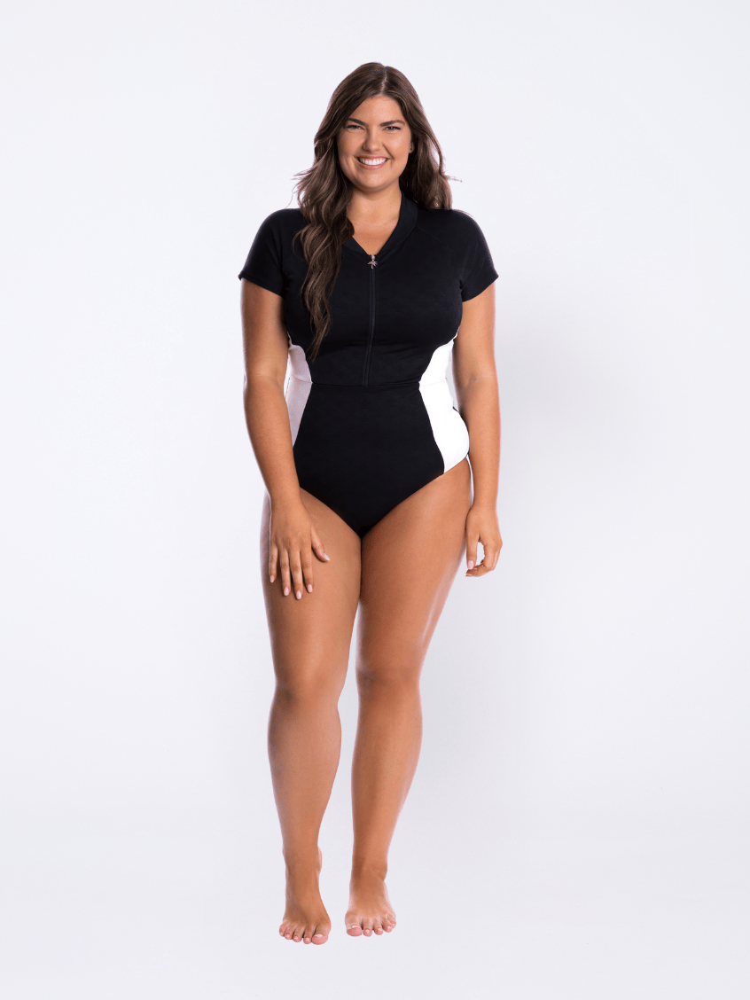 Model in studio wearing black and white cap sleeve one piece in textured print