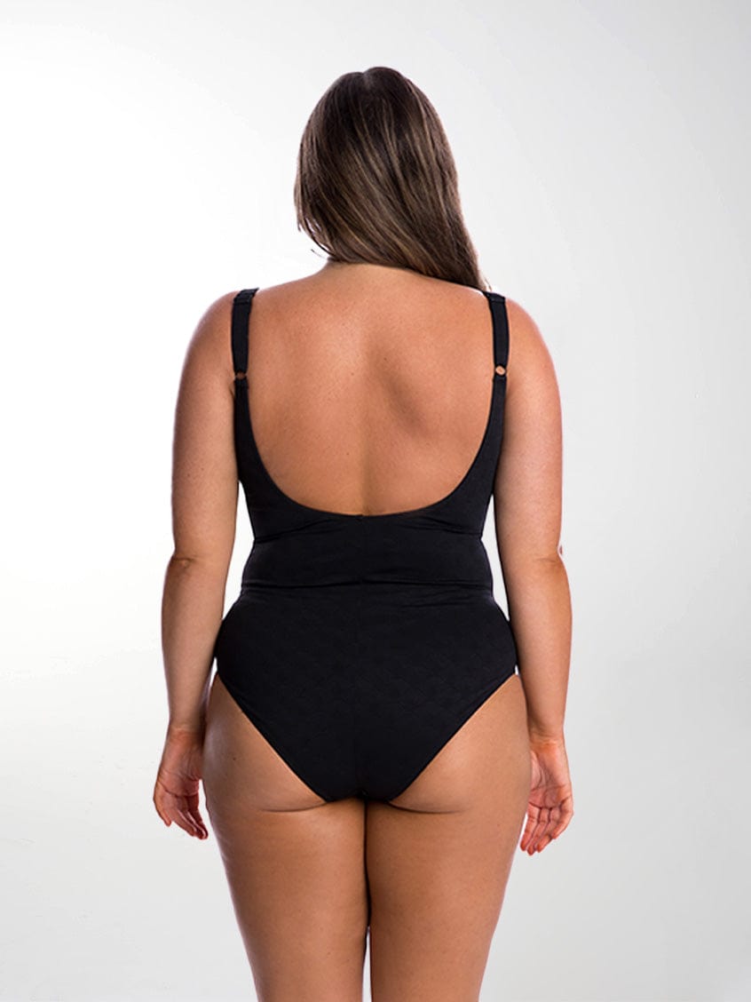 Back of model in studio wearing criss cross textured one piece with scoop back and adjustable straps