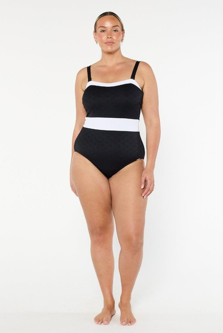Woman wearing a black and white swimsuit on a white background