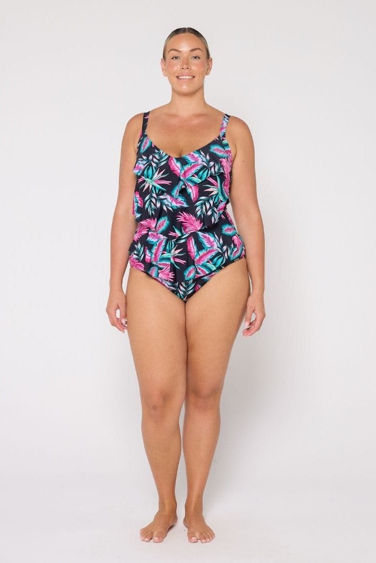 Woman wearing a tropical leaf patterned swimsuit on a white background