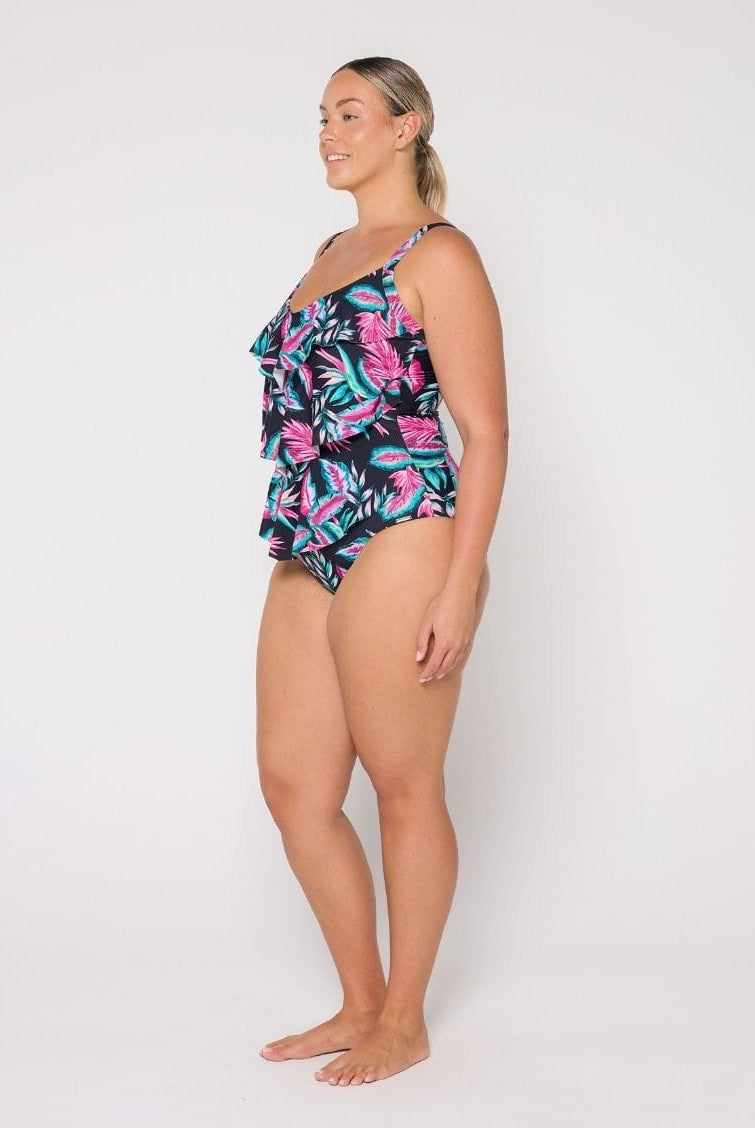 Woman wearing a tiered designfloral swimsuit on a white background