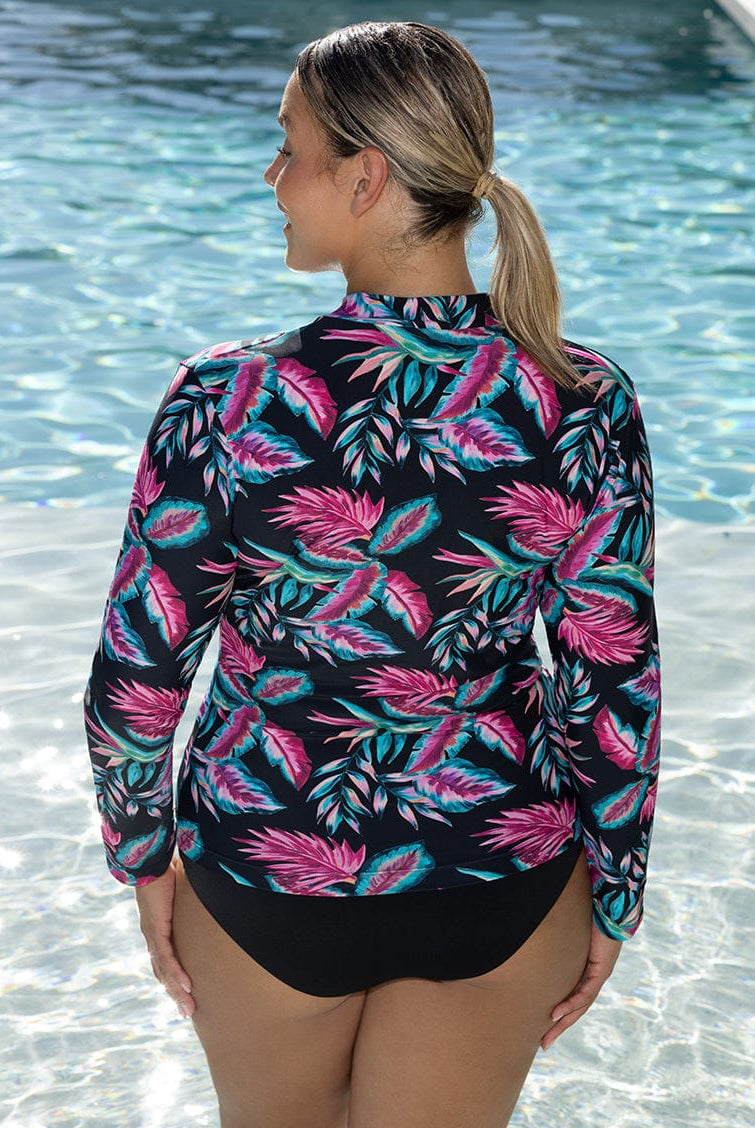 Woman wearing a colorful leaf-patterned swimsuit by a pool
