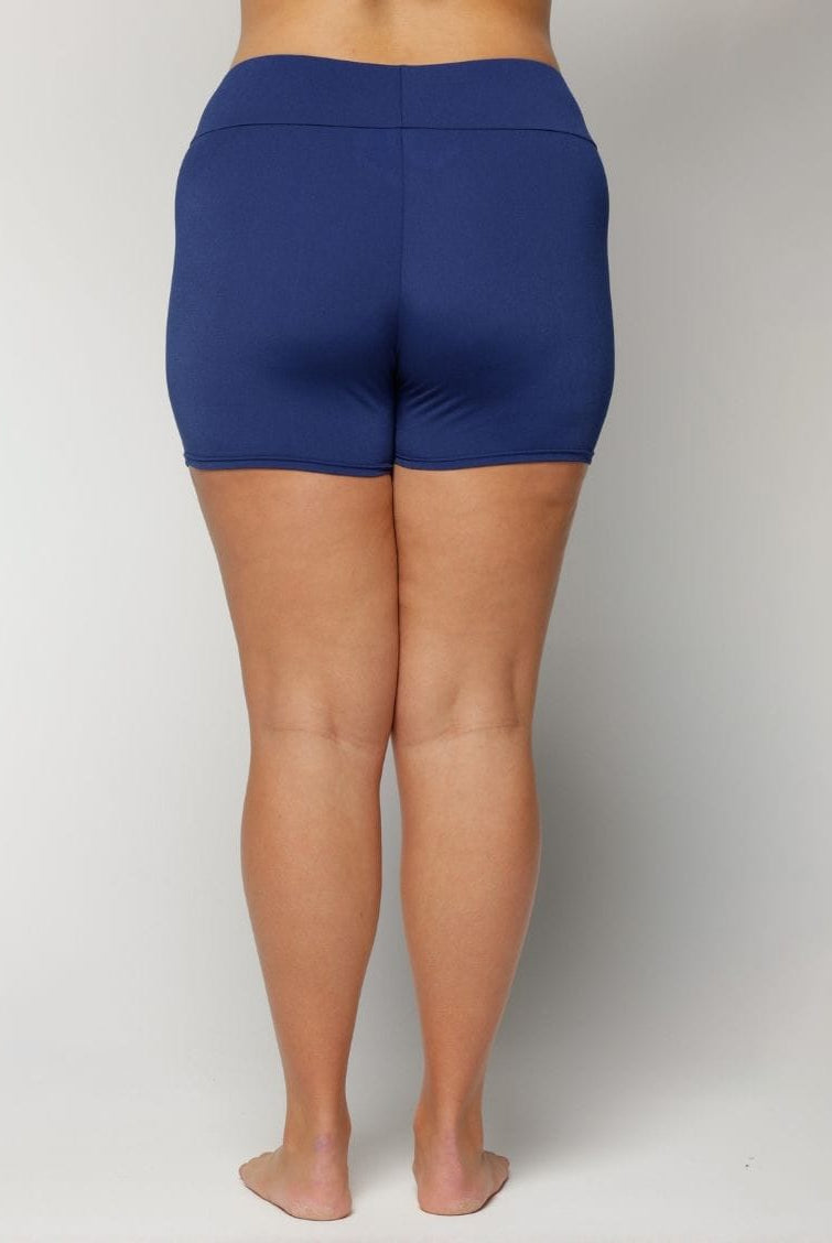 Person wearing blue shorts on a plain background