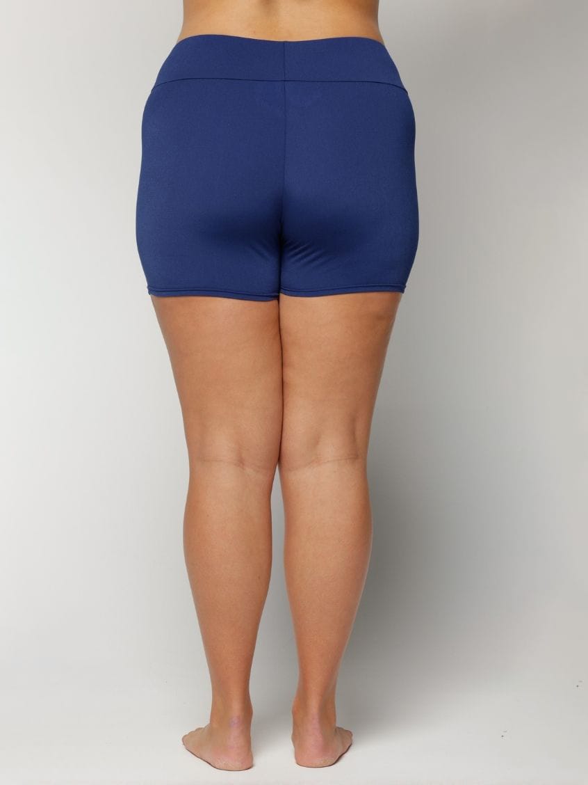 Person wearing blue shorts on a plain background