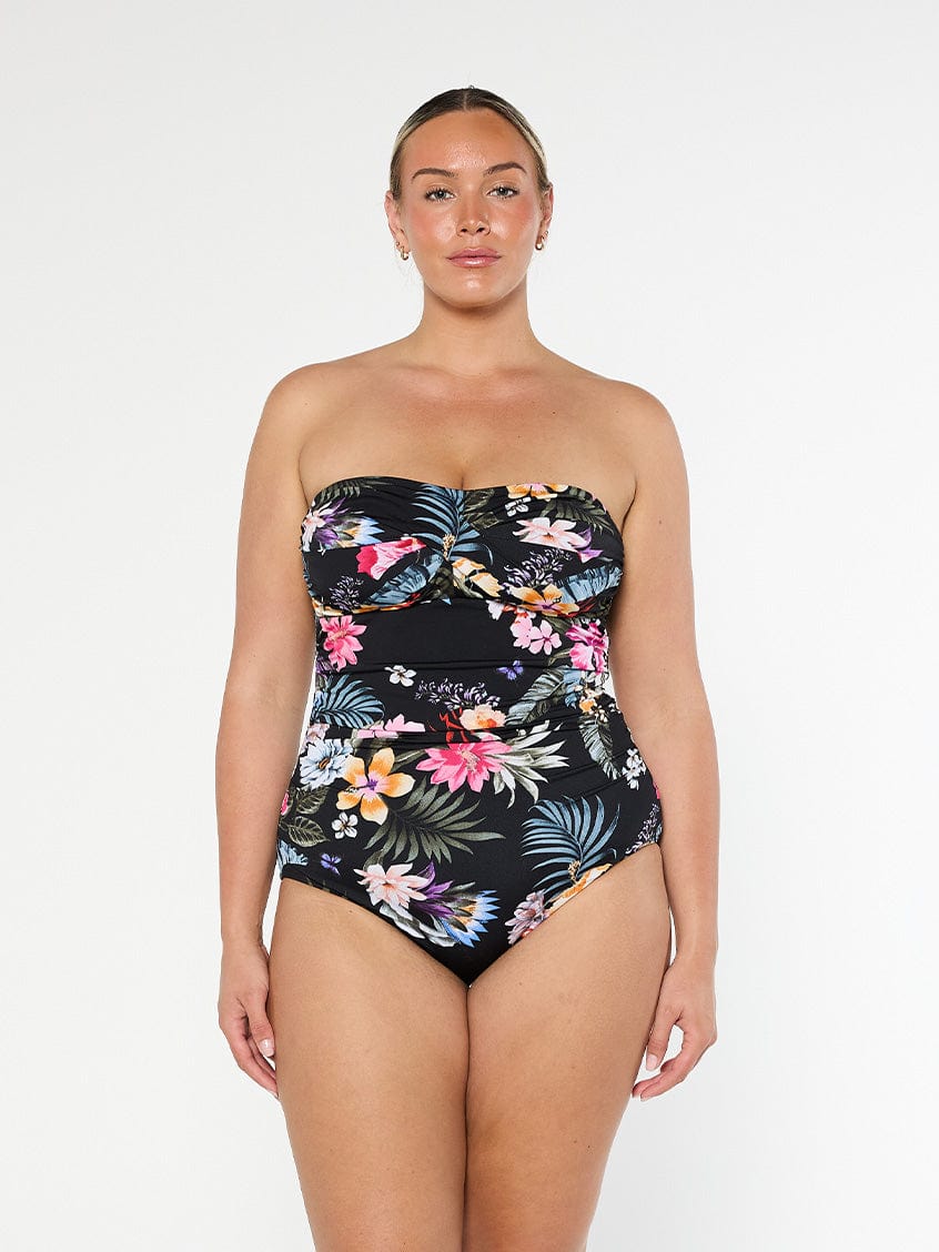 Blonde model shows strapless chlorine resistant swimsuit in black floral fabric