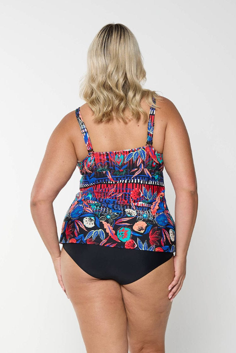 Back of model wearing tankini top with multi coloured pattern on it with adjustable and removable straps