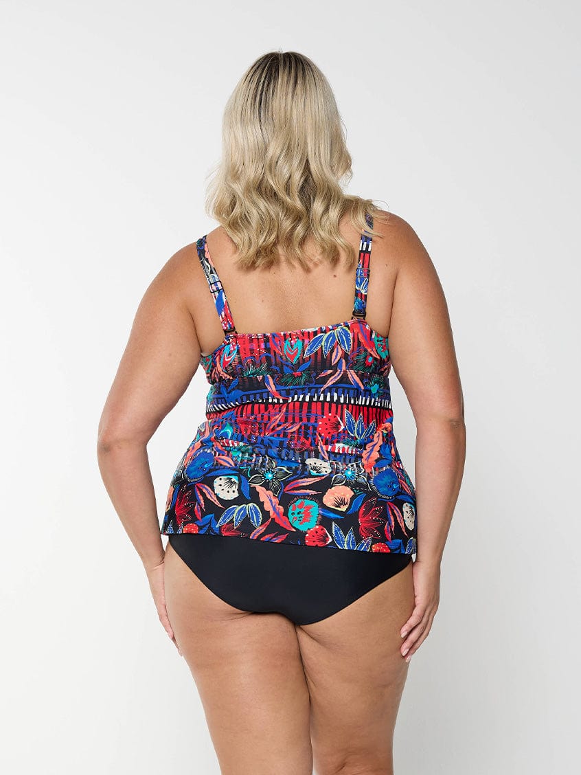 Back of model wearing tankini top with multi coloured pattern on it with adjustable and removable straps