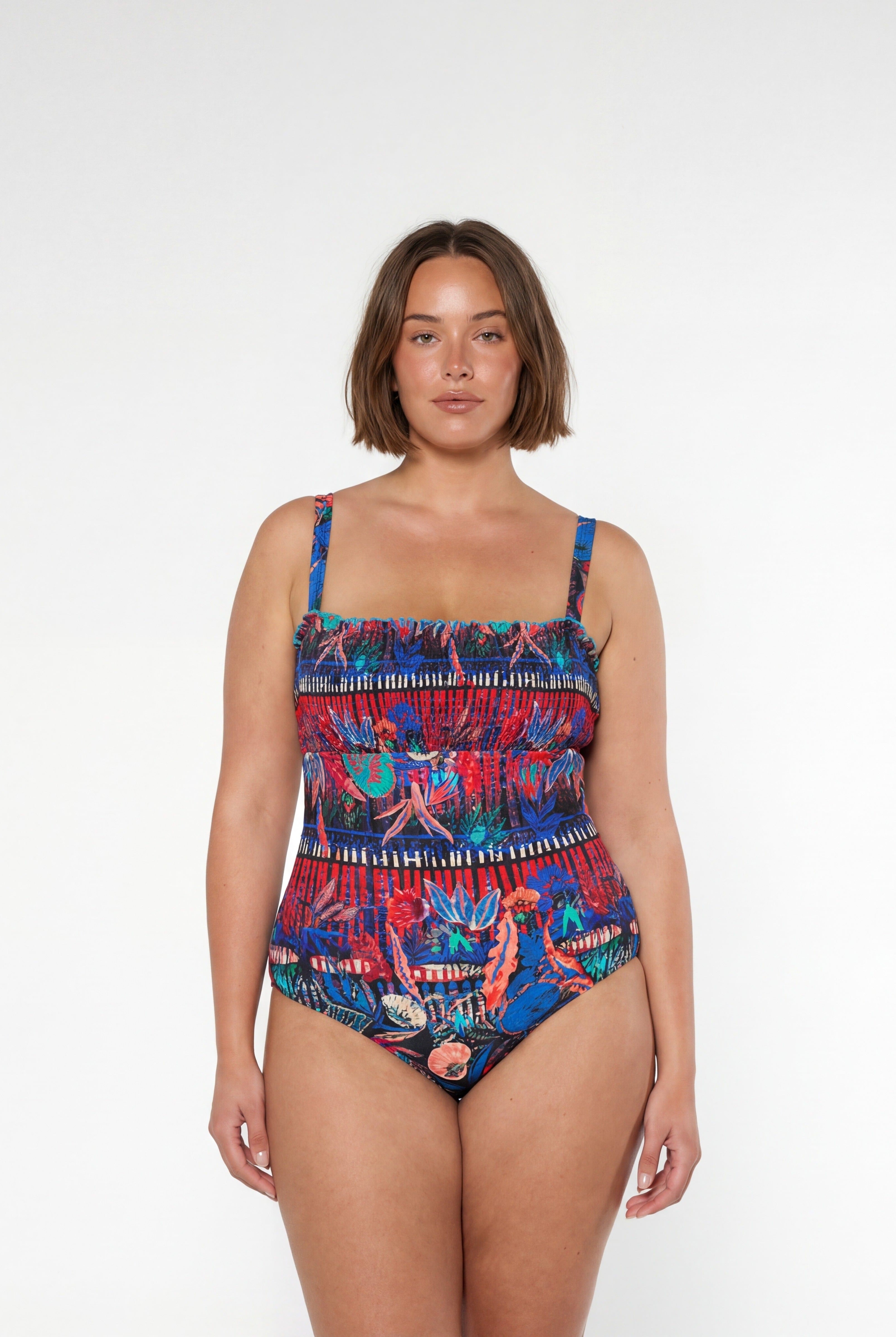 Woman wearing a colorful patterned swimsuit on a white background