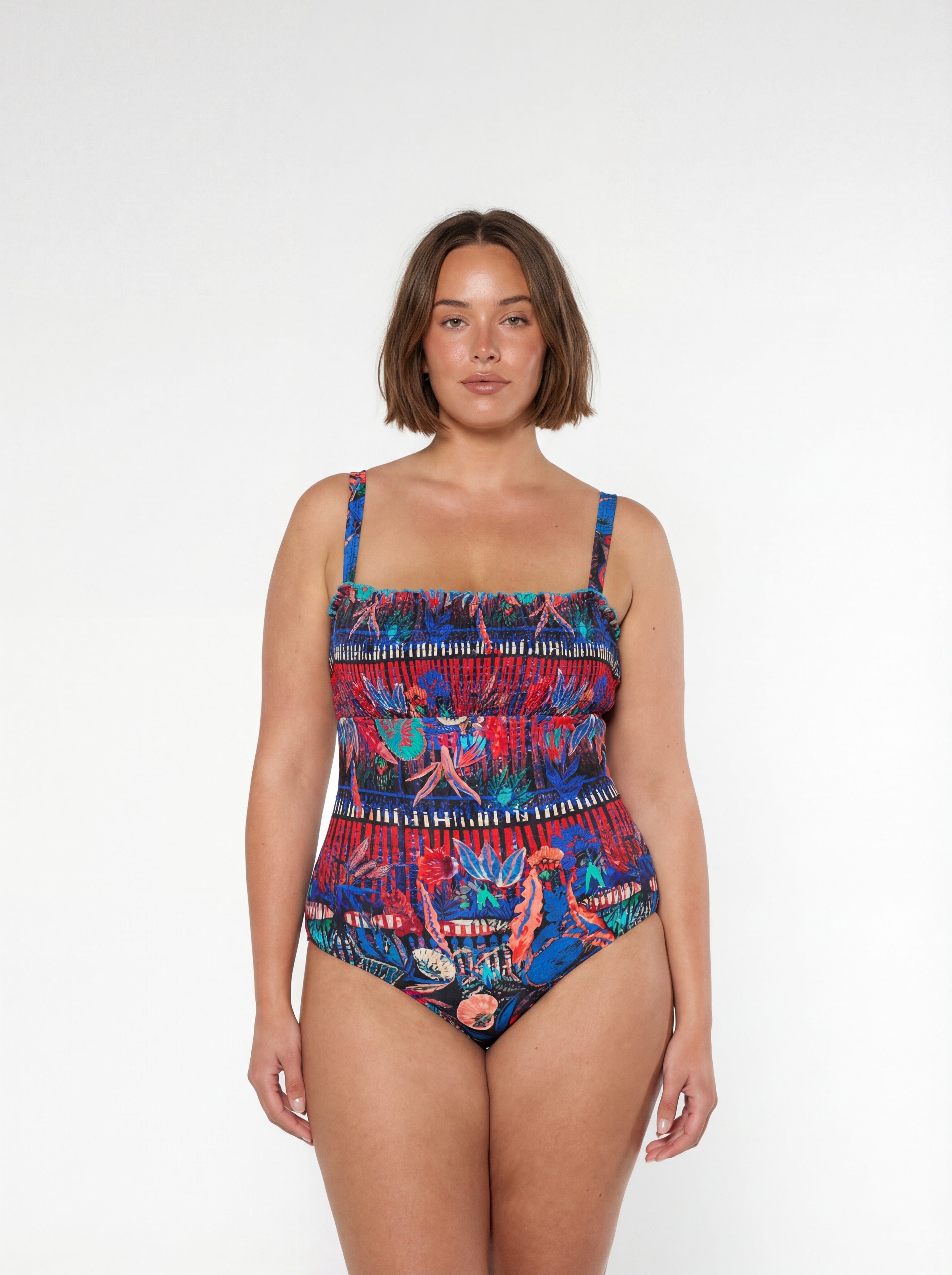 Woman wearing a colorful patterned swimsuit on a white background