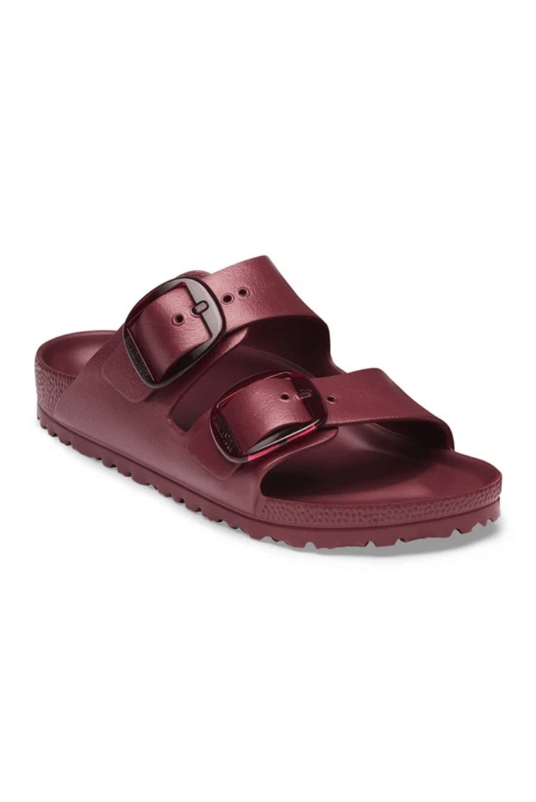 A single metallic burgundy double-strap slide sandal with black buckle details, shown from a three-quarters angle on a white background.