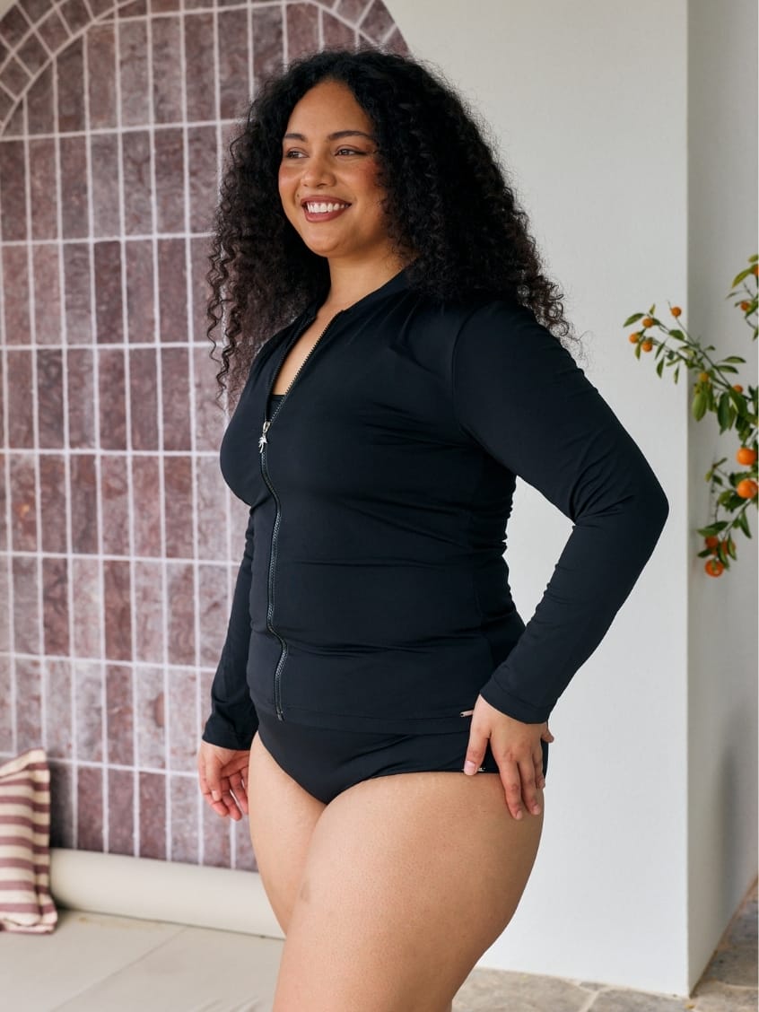 Model wears a long sleeve rashie with zip detail in chlorine resistant