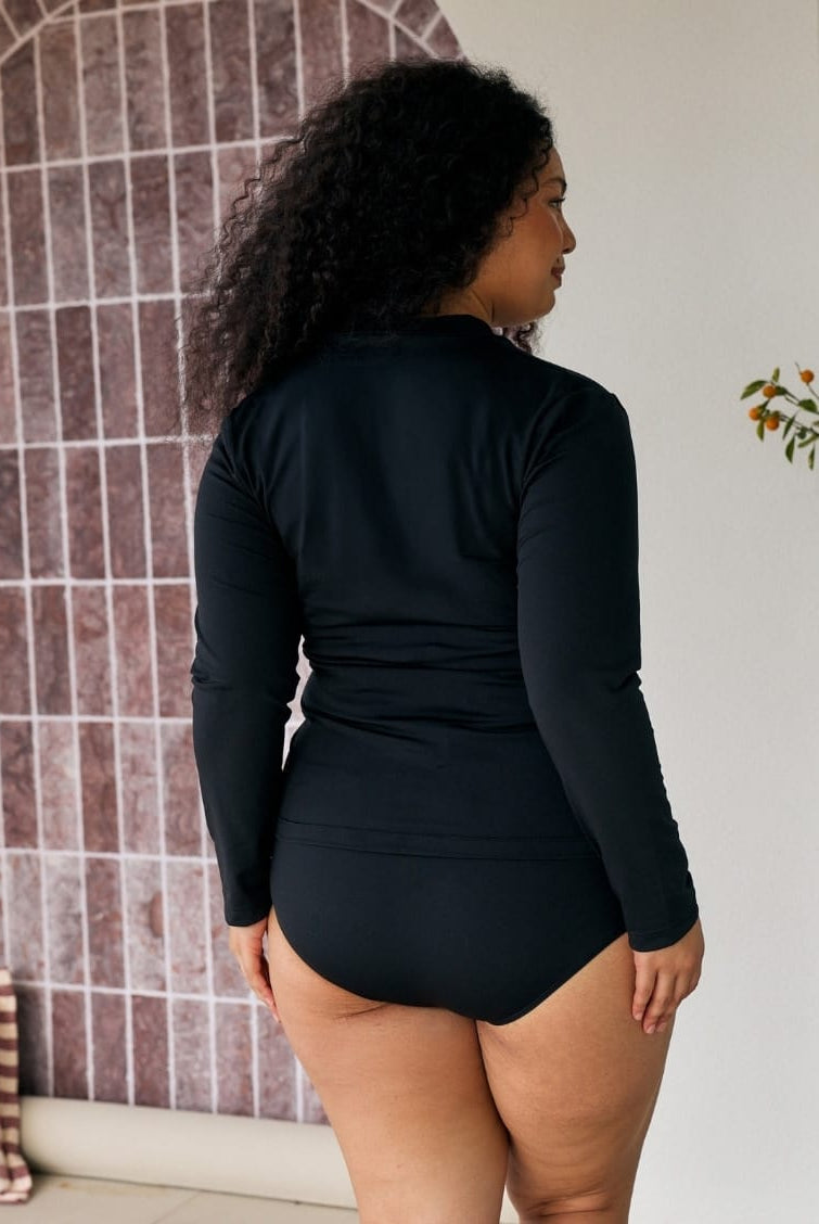 Back of model wearing a long sleeve chlorine resistant rashie in black