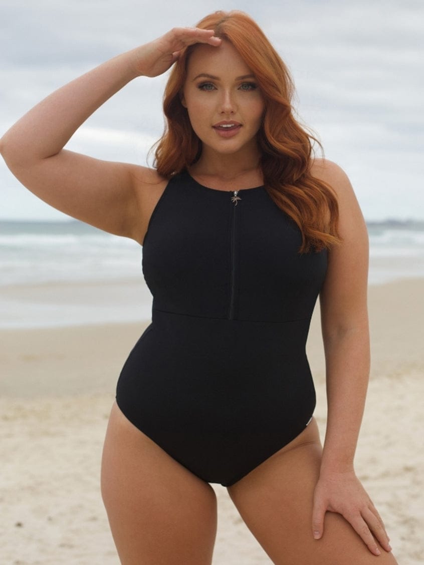 Woman in a black swimsuit standing on a beach