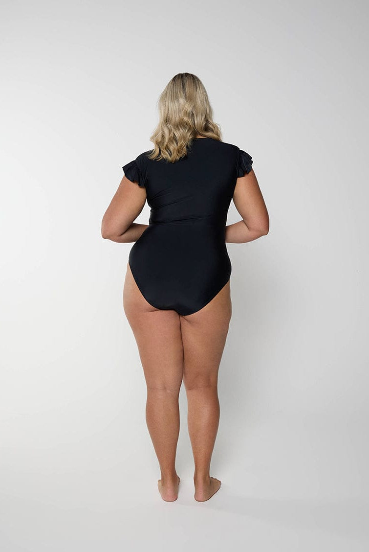 Person wearing a black bodysuit on a white background