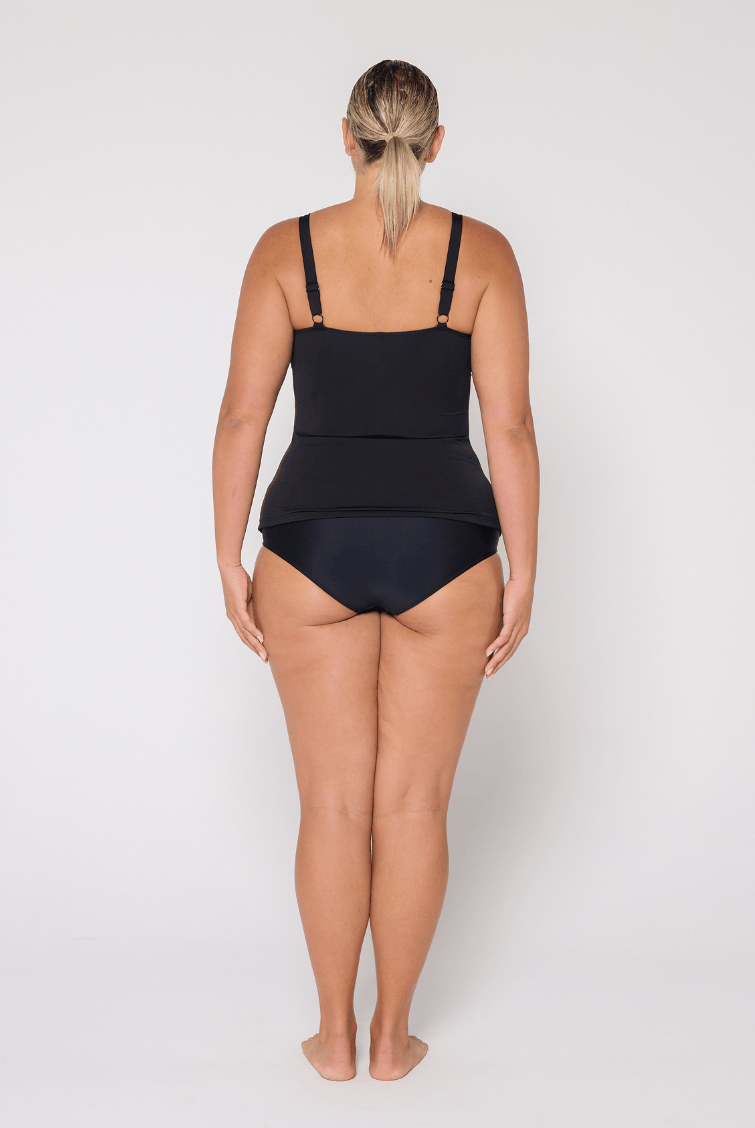 Side profile of woman in studio wearing a high neck tankini top with adjustable straps