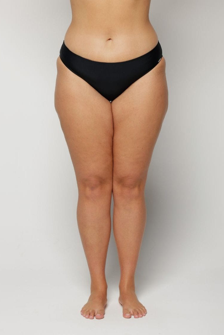 Person wearing black underwear on a plain background