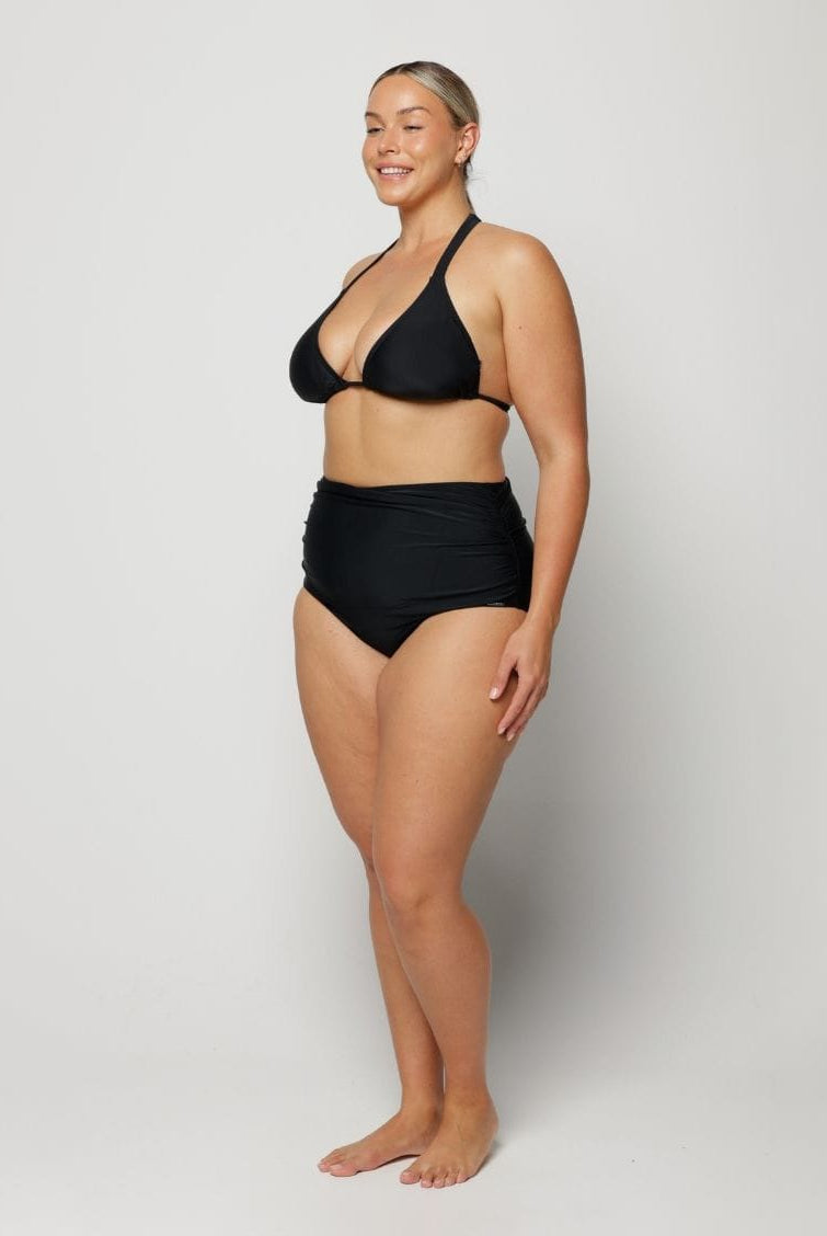 Woman wearing a black bikini on a plain background