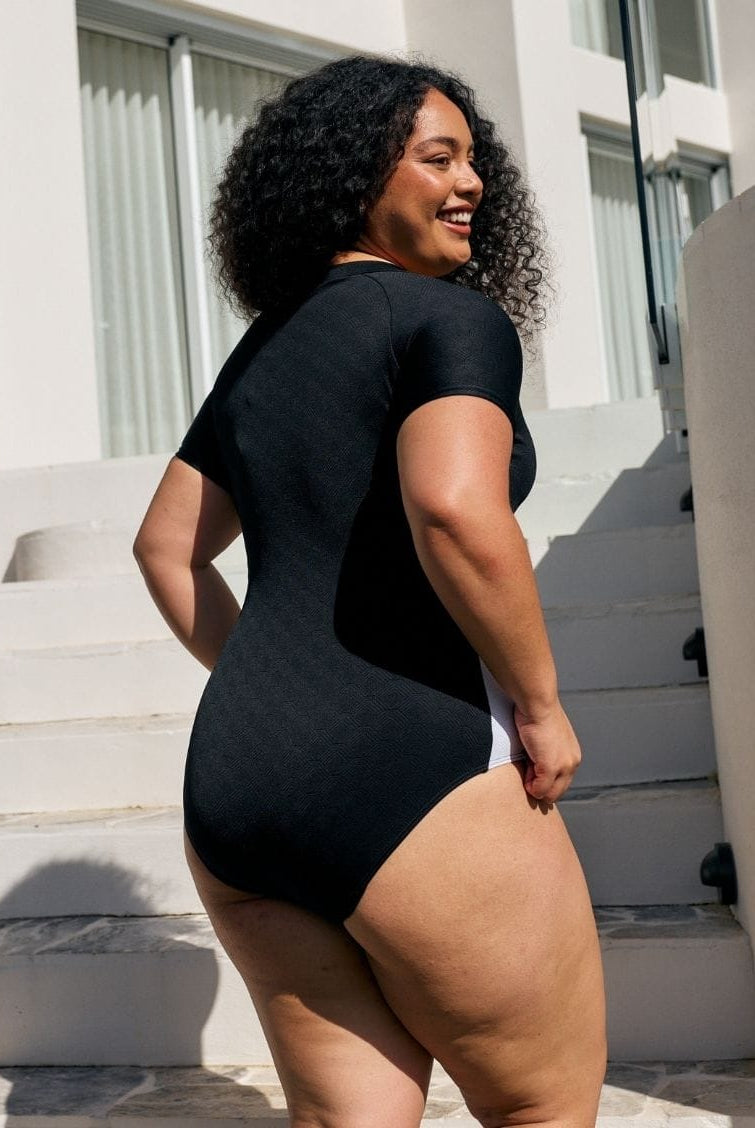 Back of model wearing a high neck one piece