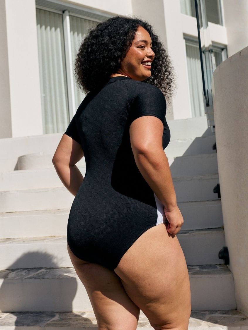 Back of model wearing a high neck one piece