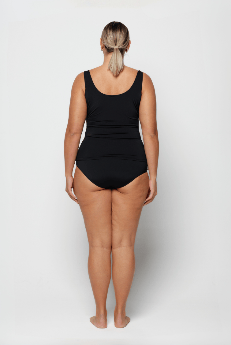 Person wearing a blue and black chlorine resistant swimsuit on a white background with high back
