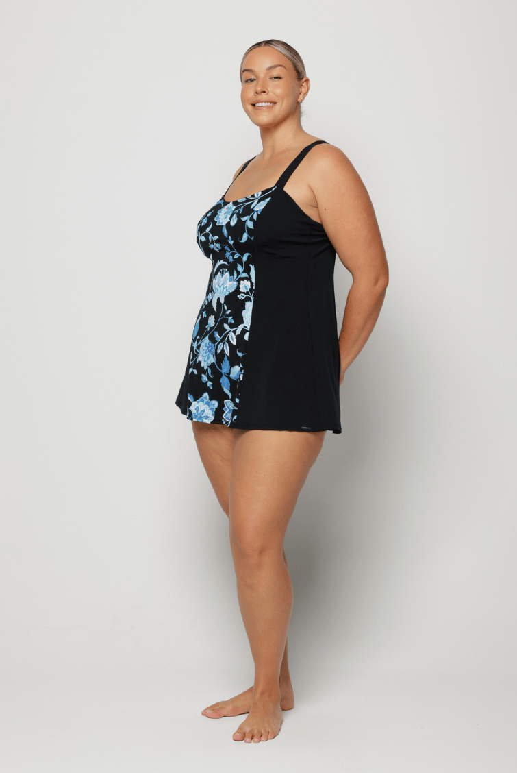 Woman wearing a black and blue floral dress against a white background