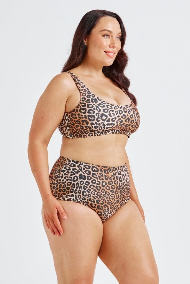 Woman wearing a leopard print swimsuit on a white background