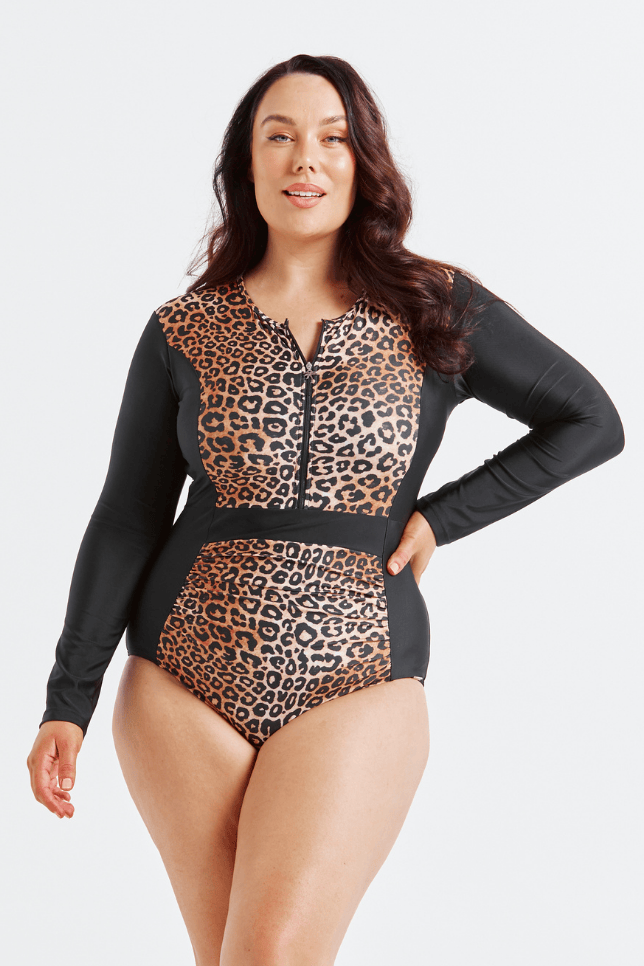 Woman wearing a leopard print and black long-sleeve swimsuit on a white background