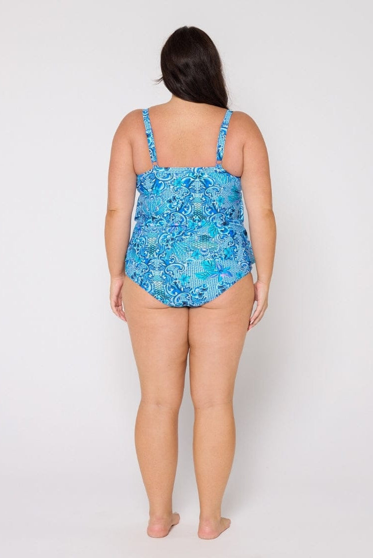 Woman wearing a blue floral swimsuit against a white background