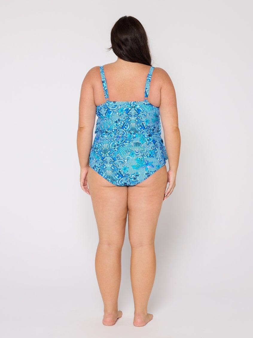 Woman wearing a blue floral swimsuit against a white background