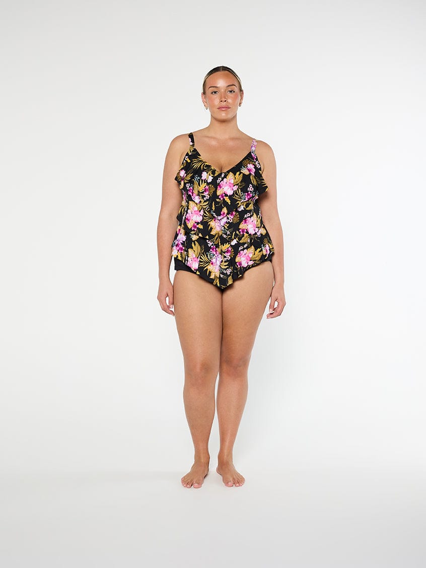 Woman wearing a floral one-piece swimsuit on a white background