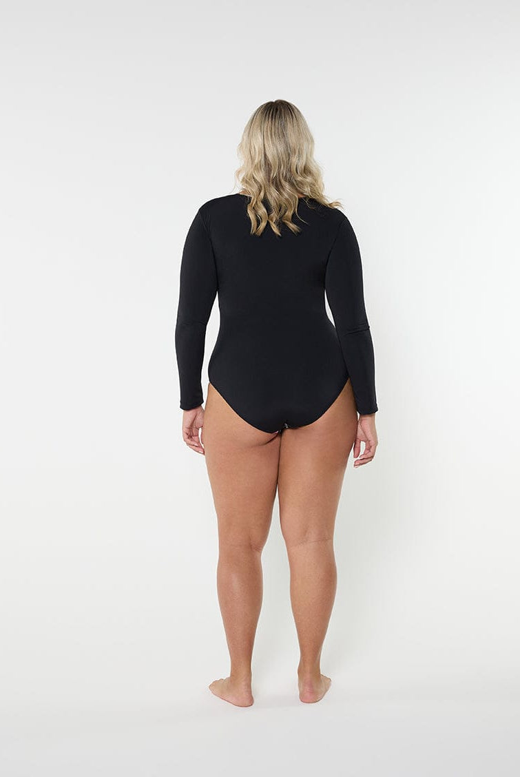 Person wearing a black swimsuit with long sleeves on a white background