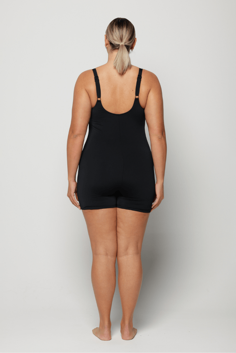 Person wearing a black boyleg one peice on a white background