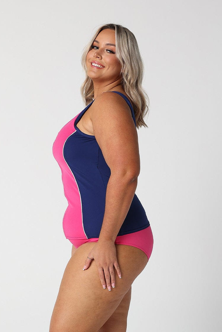 Side profile of blonde model in studio wearing navy and pink tankini top for curvy woman