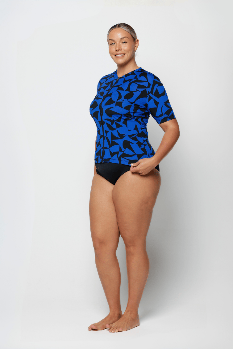Person wearing a blue and black patterned swimsuit on a white background