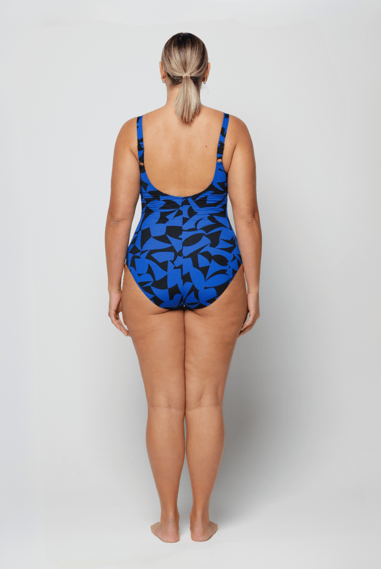 Person wearing a blue and black patterned swimsuit on a white background