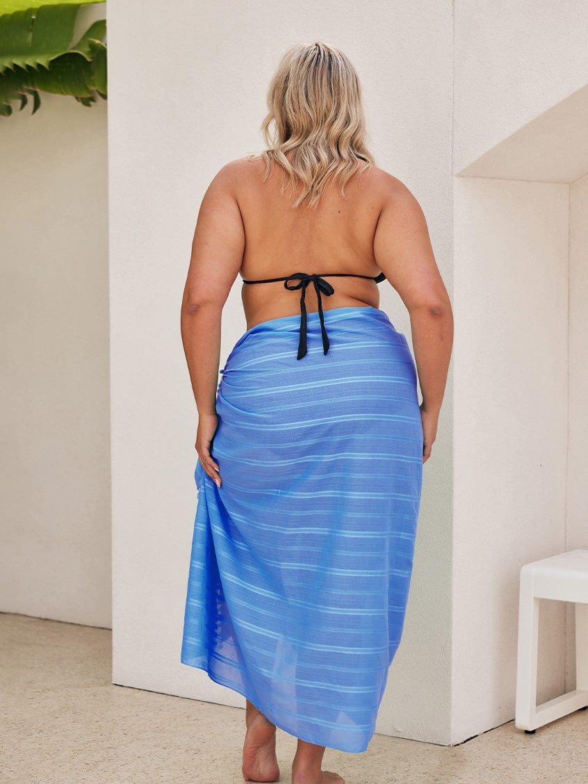 Back of plus size model wearing maxi blue sarong skirt with tie detail
