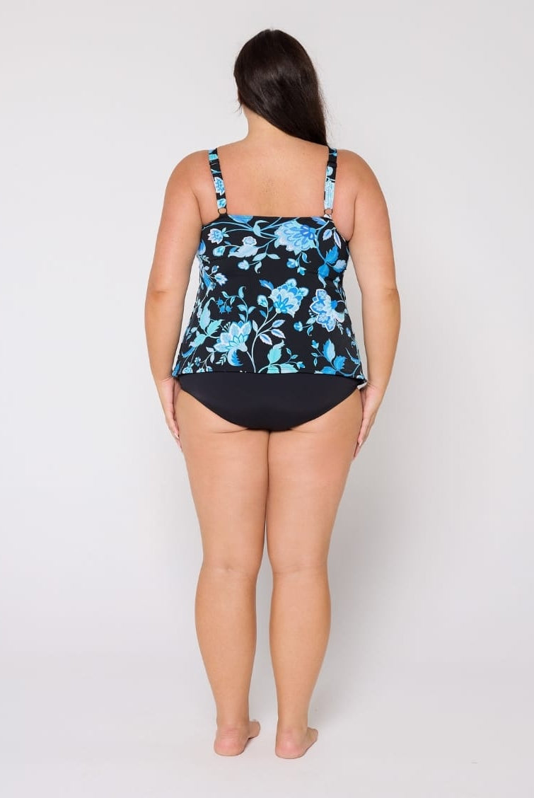 Woman wearing a black and blue floral tank tankini in chlorine resistant with adjustable straps