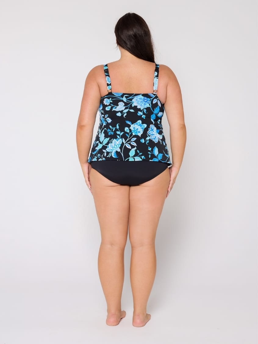 Woman wearing a black and blue floral tank tankini in chlorine resistant with adjustable straps