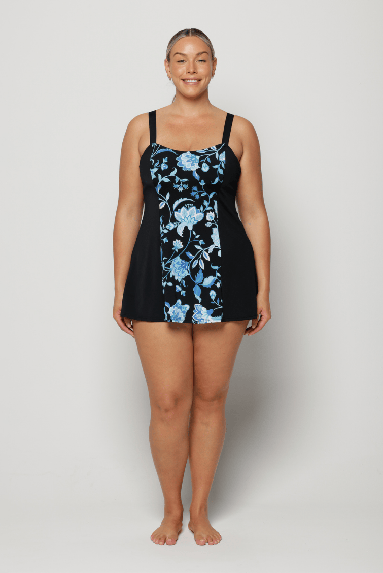 Woman wearing a black swimsuit with blue floral pattern on a white background