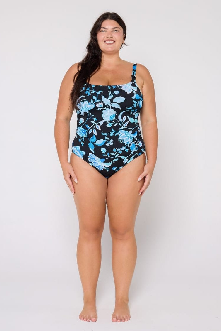 Woman wearing a blue floral swimsuit on a white background