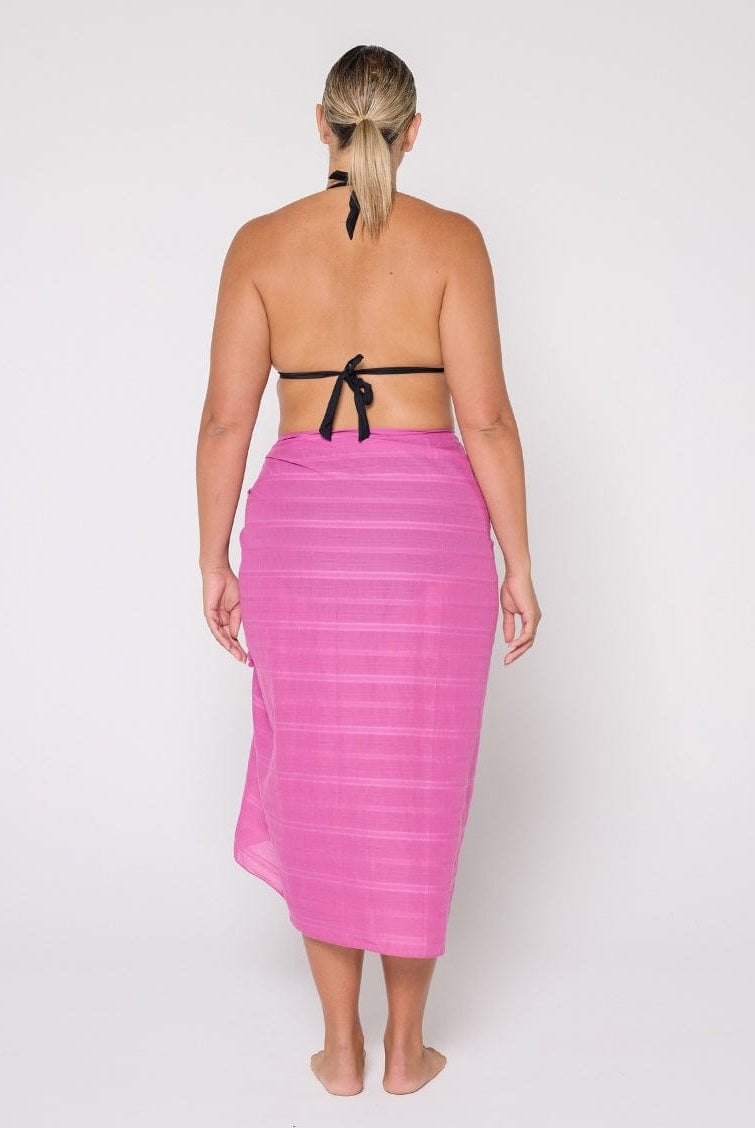 Woman wearing a pink sarong with a white background