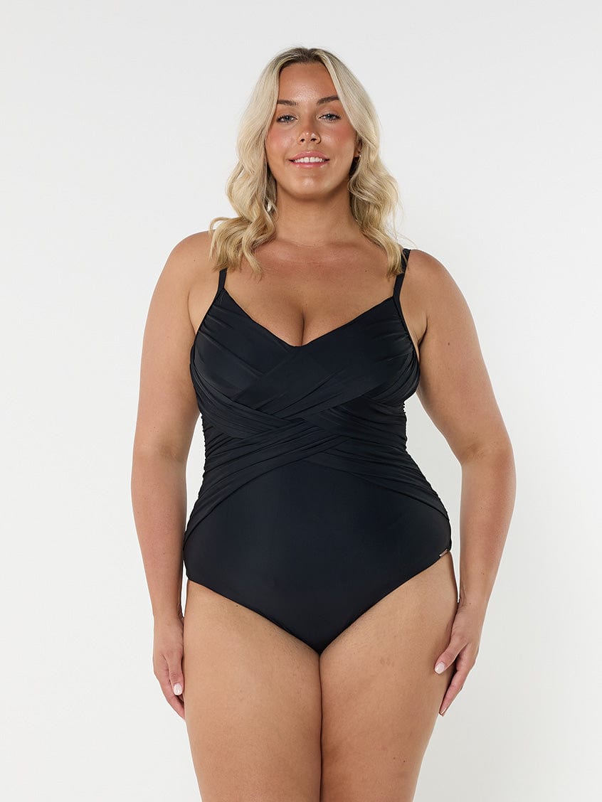 Blonde model in studio wearing criss cross one piece for curve women