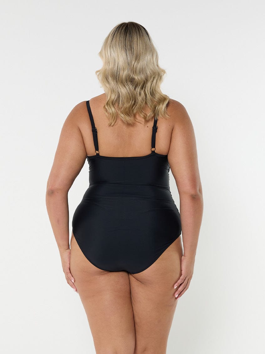 Blonde model showing back of black criss cross one piece swimsuit