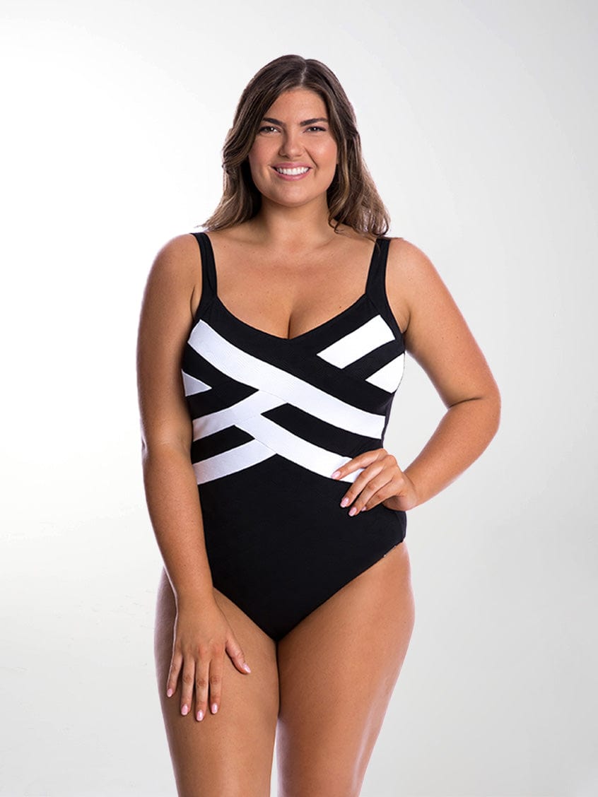 Brunette model in studio wearing criss cross one piece in black and white for curve woman