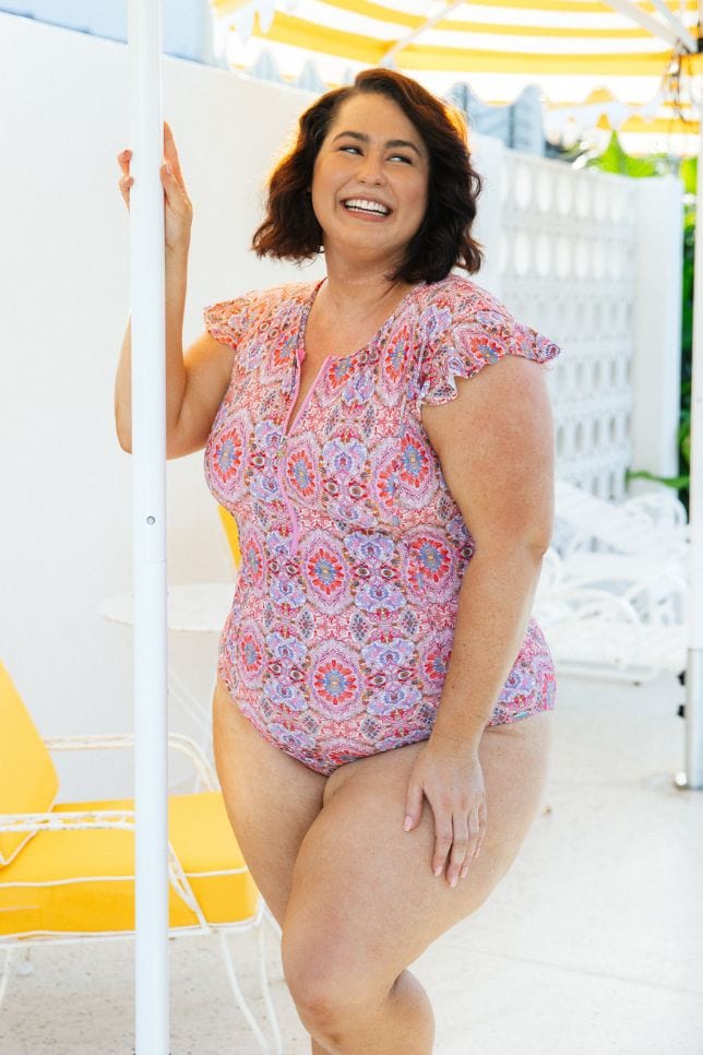plus size model wearing pink paisley high neck one piece
