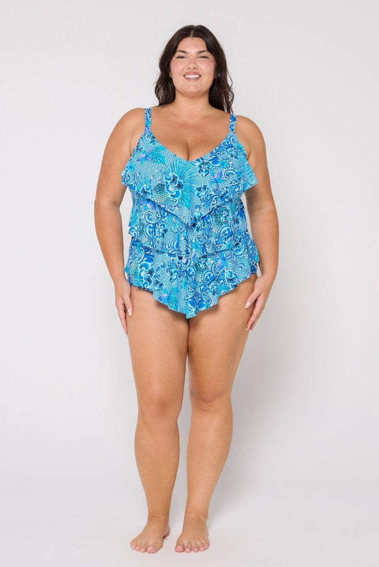 Woman wearing a blue floral swimsuit against a white background