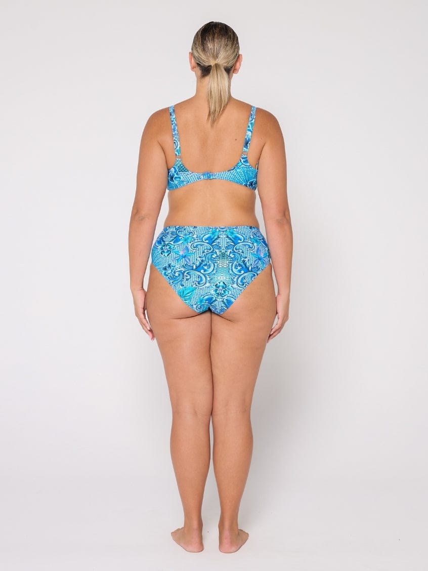 Woman wearing a blue patterned bikini set on a white background