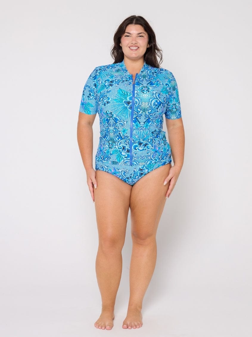 Woman wearing a blue patterned swimsuit on a white background